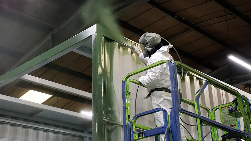 A SurfacePrep paint specialist painting a new blast room during production A SurfacePrep paint specialist painting a new blast room during production