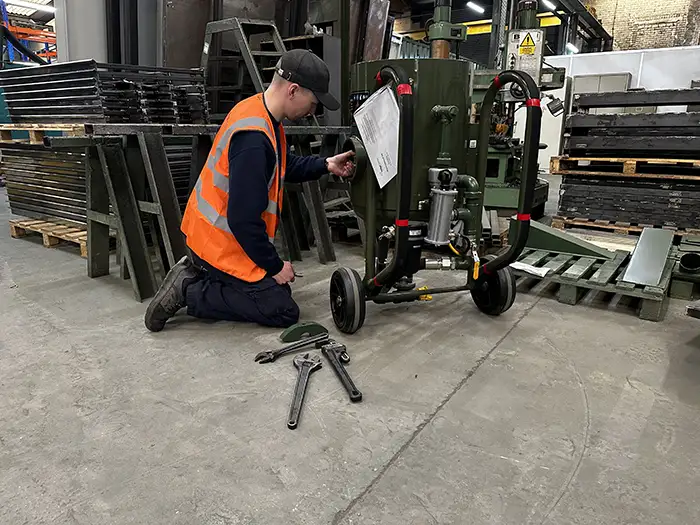 Service engineer maintaining a blast pot