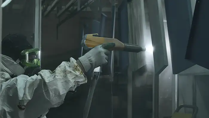 Worker spray paints metal sheets Worker spray paints metal sheets