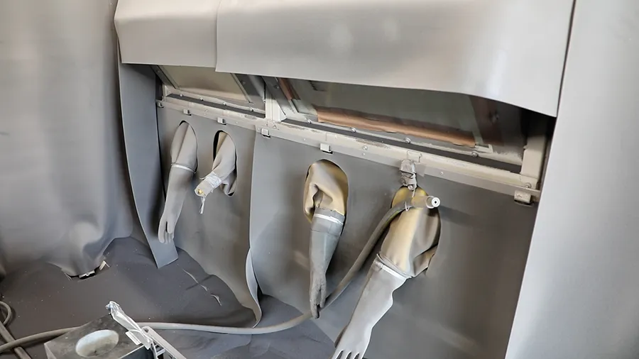 Inside the containerised blasting booth showing the internal blasting gloves
