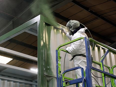 A SurfacePrep paint specialist painting a new blast room during production